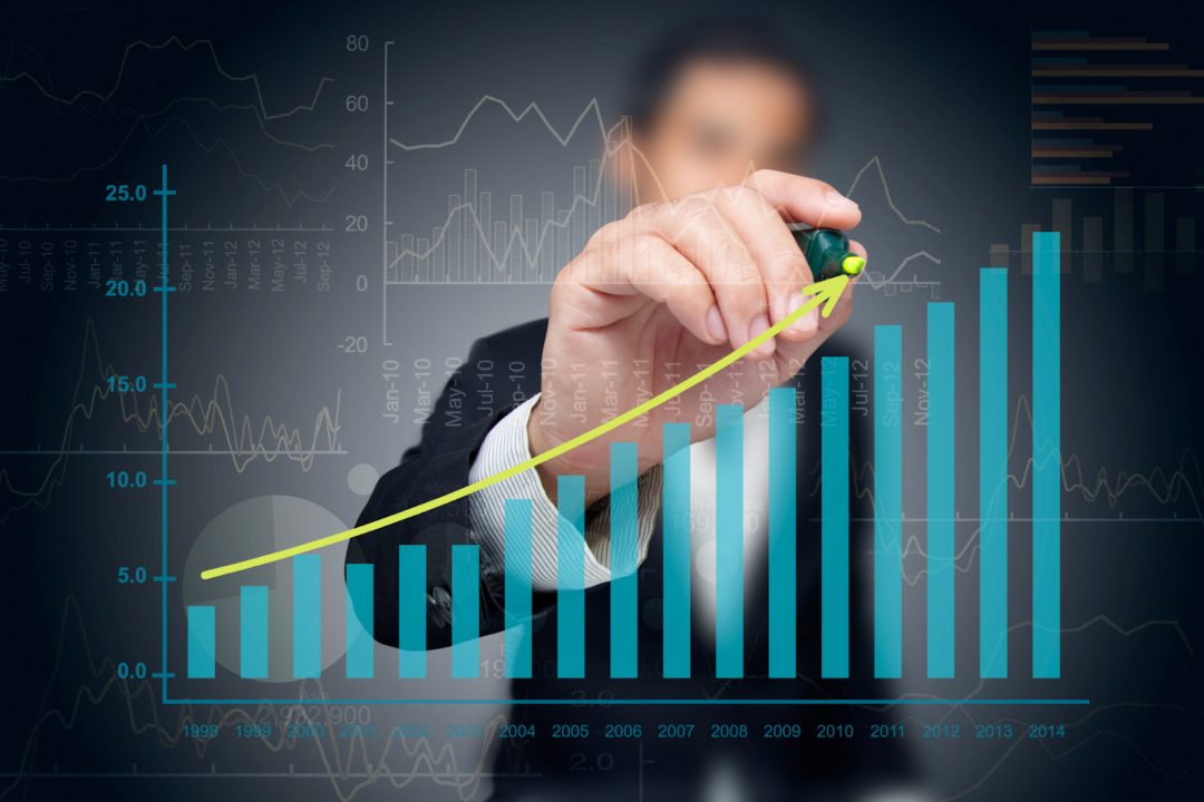 A man drawing a line above a statistically line graph